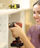 Muchacha instalando puerta de mueble con taladro inalambrico rotomartillo